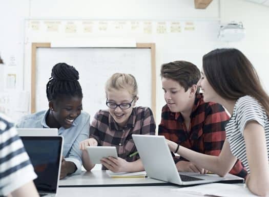 Middle school kids gathered together studying